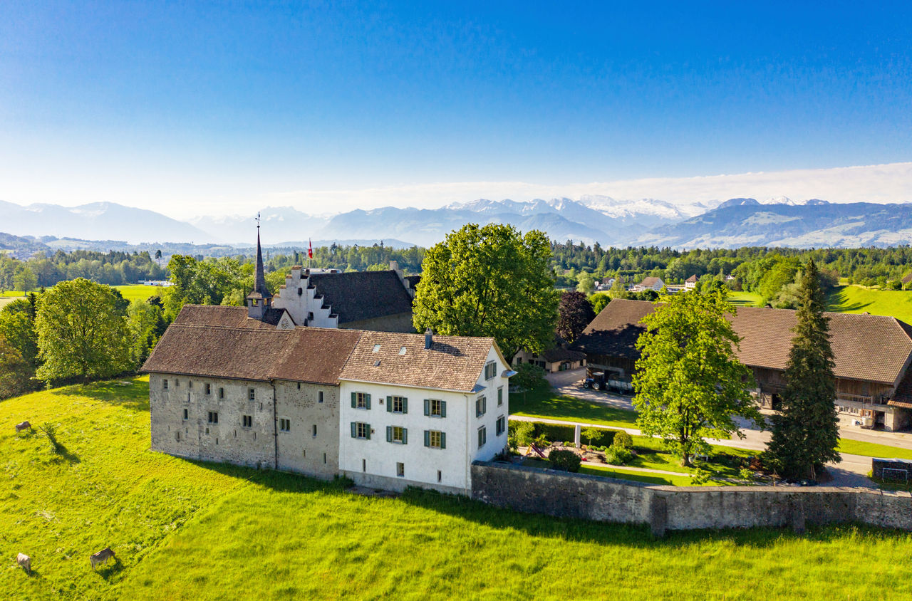 Das Ritterhaus Bubikon mit den Alpen im Hintergrund.