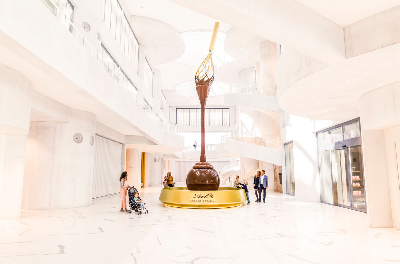 Besucherinnen und Besucher bestaunen den Schokoladenbrunnen im Lindt Home of Chocolate