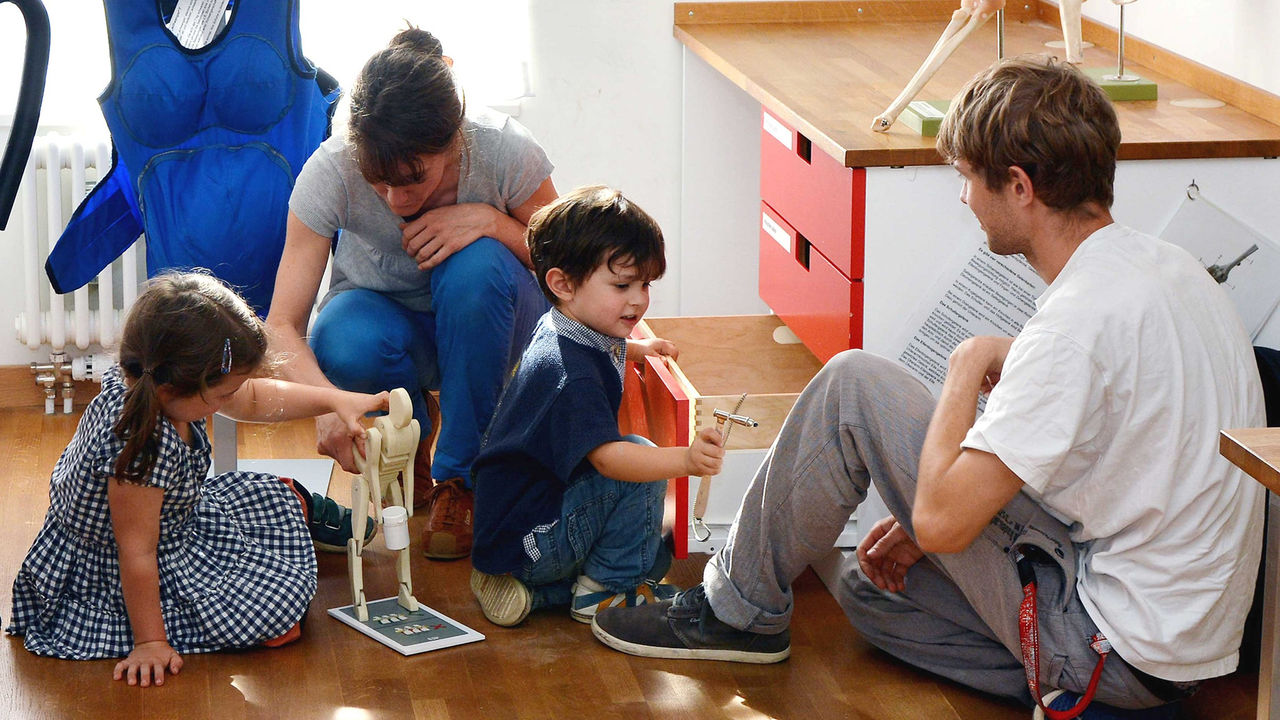 Eine Familie spielt gemeinsam mit Ausstellungsstücken im Kulturama.
