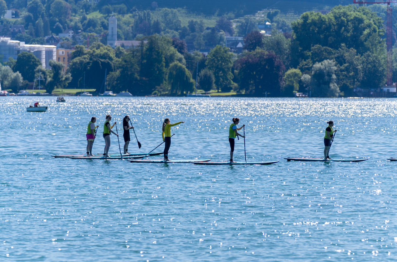 Eine Gruppe paddelt mit SUPs von Supkultur über den Zürichsee.