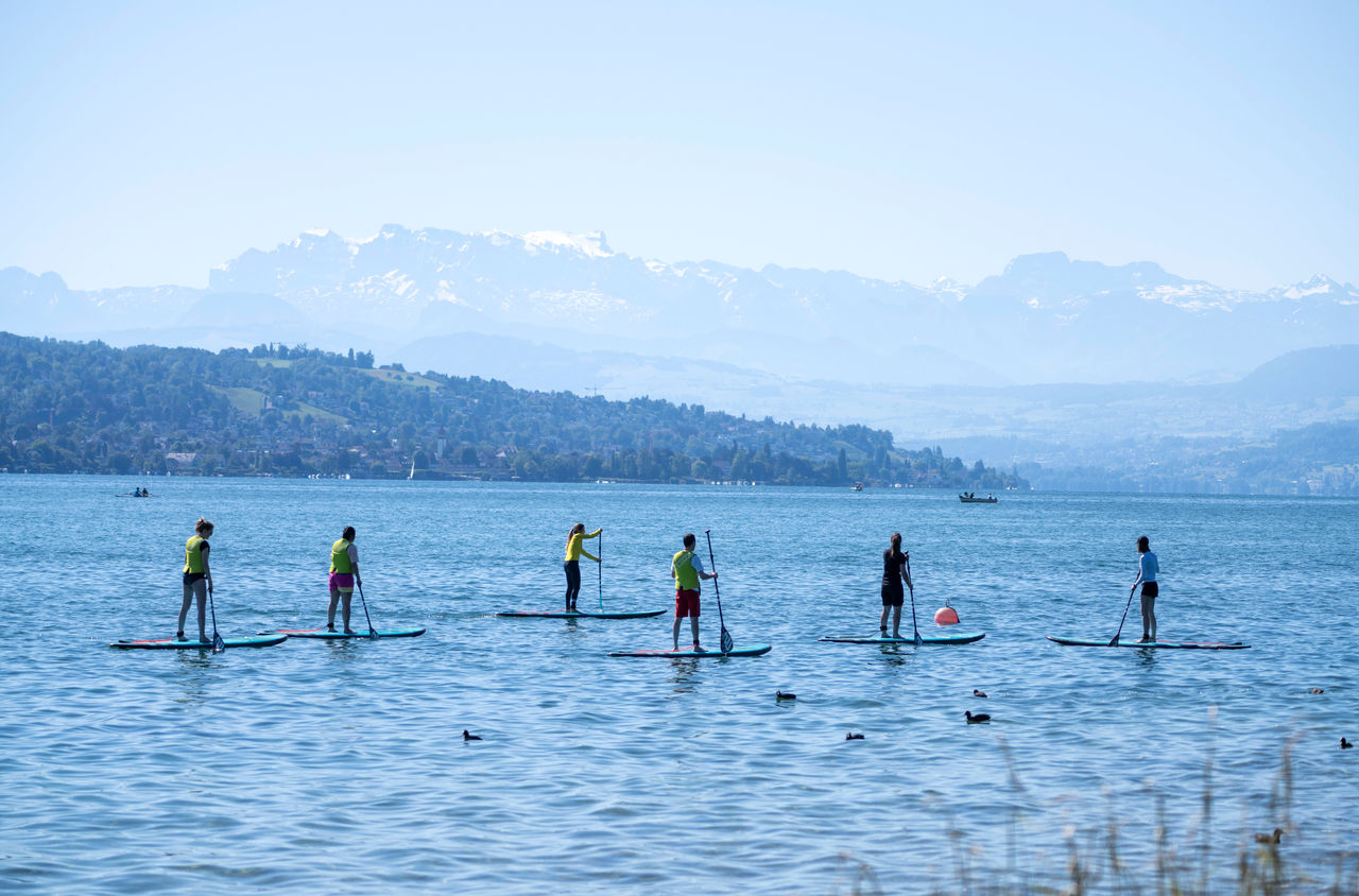 Eine Gruppe paddelt auf SUPs von Supkultur über den Zürichsee