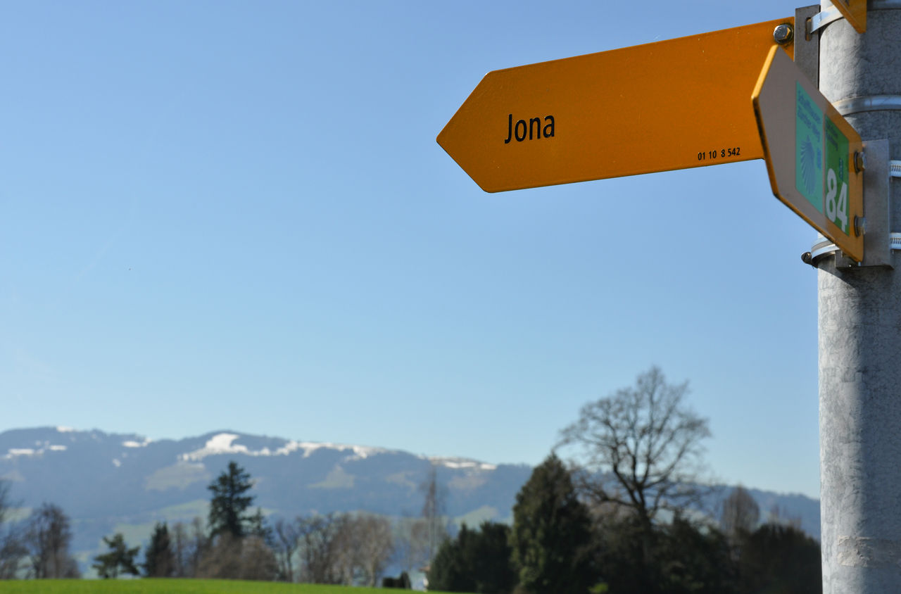 Gelber Wegweiser zeigt nach Links mit Aufschrift "Jona"